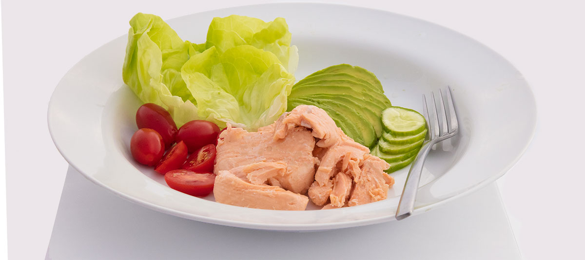 Live Ocean Salmon served on white plate with salad trimmings