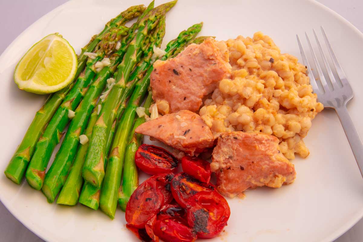 prepared meal using salmon bowl, seared asparagus with garlic butter, roasted tomatoes